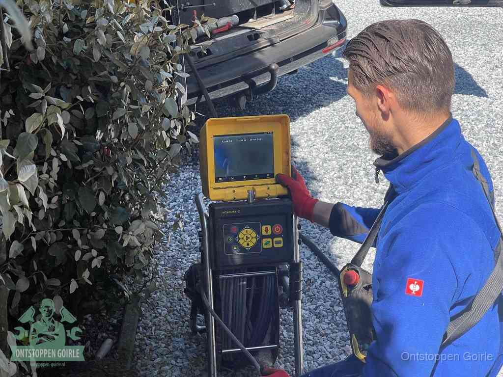 Een monteur bedient een rioolinspectiecamera met monitor en haspel om de verstopping in beeld te brengen in Goirle