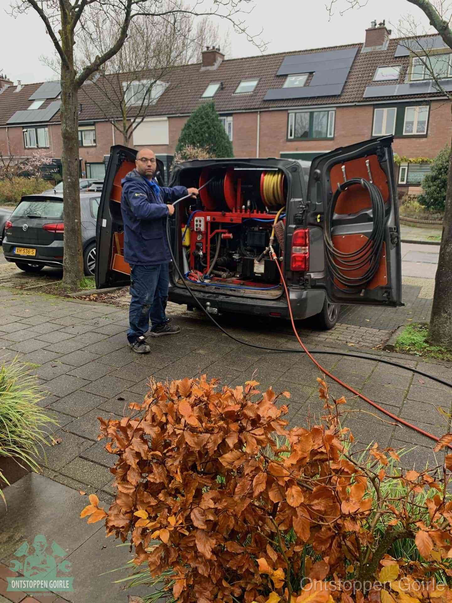 Een monteur staat bij zijn open bestelbus met hogedruk-rioolreinigingsapparatuur, klaar om binnen 30 minuten uit te rukken voor een spoedverstopping in Goirle