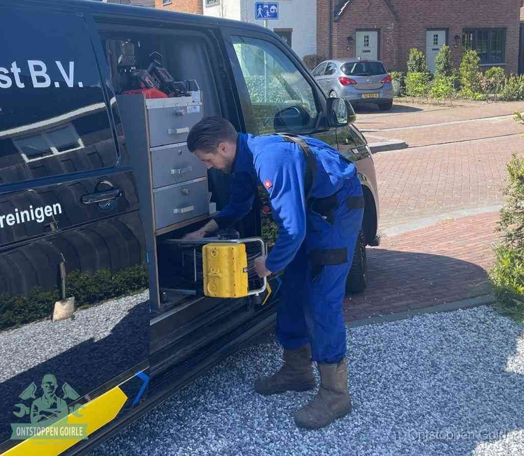 Een monteur pakt gereedschap uit de bedrijfsbus, het moment om een professionele ontstoppingsdienst in te schakelen in Goirle